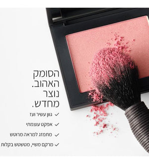 תמונה המציגה סומק בגוון ורוד באריזה מרובעת פתוחה, כאשר מברשת איפור מונחת על הסומק ועליה אבקה מהסומק. משמאל מופיע טקסט בעברית: "הסומק האהוב. נוצר מחדש." ומתחתיו רשימה: "גוון עשיר ועד", "אפקט עוצמתי", "מתמזג למראה מרוטש", "מרקם משיי, מטשטש בקלות".