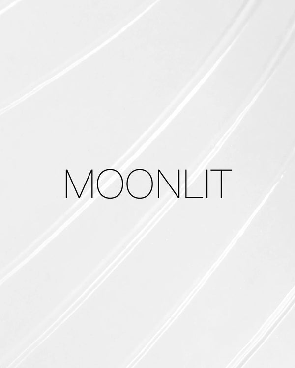 מריחה של סטיק הארה רב-שימושי Light Reflecting Luminizing Stick של NARS בגוון Moonlit, על רקע בהיר. התמונה מדגישה את הפורמולה השקופה ואת הגימור הזוהר והקורן של המוצר.