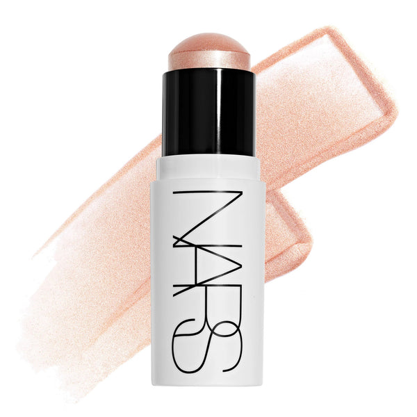 סטיק ההארה Light Reflecting Luminizing Stick של NARS בגוון Total Eclipse, מוצג פתוח לצד מריחה של הפורמולה על רקע בהיר. התמונה מדגישה את גוון הברונזה החמים ואת הגימור הזוהר והקורן, המעניק הארה טבעית וברק עשיר לעור.